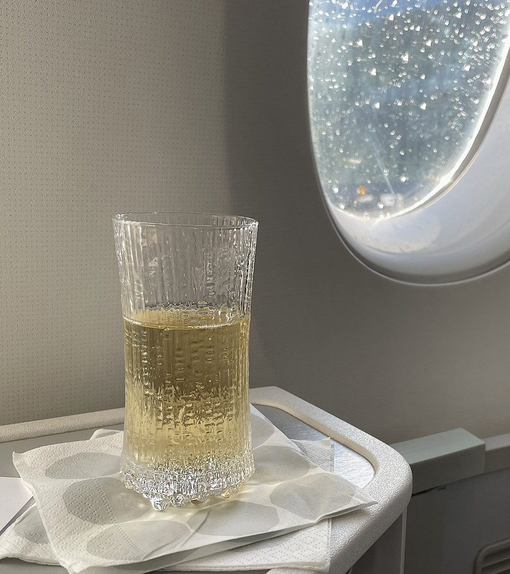 A glass of champagne on a side table beside the window in the Salon cabin